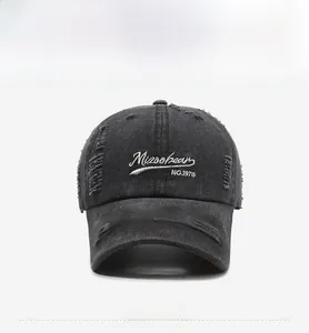 Detail of black distressed baseball cap with Misoobean embroidery and ripped edges