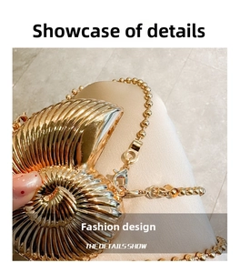 Detailed close-up of a gold seashell-shaped evening bag with spiral metal texture and chain