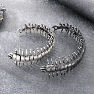 Macro view of two centipede-shaped cuff bracelets in antique silver and black gunmetal finish