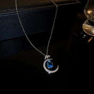 Macro view of moon and star necklace with blue water drop zircon and silver chain