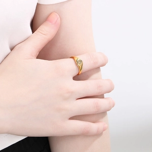 Close-up of a 18K gold plated ring featuring a starburst engraving and a central diamond