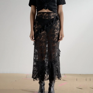 Detailed view of black sheer lace skirt with elegant ruffle trim and midi length silhouette