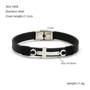Dettaglio del bracciale con croce in acciaio inossidabile e cinturino in pelle nera