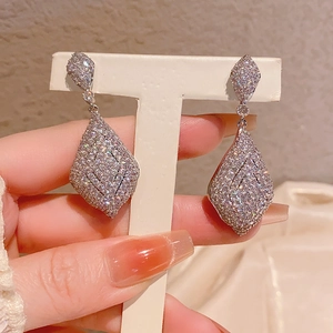 Détail rapproché de boucles d'oreilles pendantes en argent serties de zircons cubiques blancs