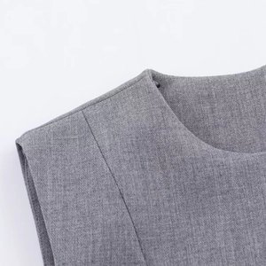 Detailed close-up of the fine gray textured fabric and shoulder stitching on a sleeveless dress