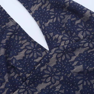 Close-up of navy blue floral lace with beige lining on a V-neck evening gown