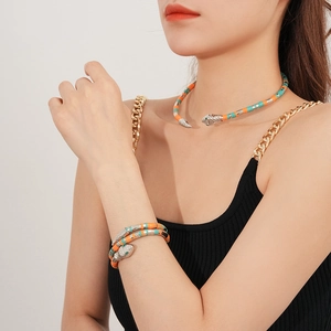 Detail of beaded snake necklace and bracelet set in orange, teal and silver on model
