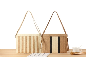 Detail of minimalist striped woven paper rope bags with dual straps in a lifestyle setting