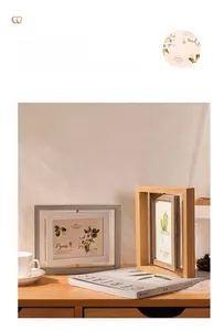 Close-up of rotating double-sided wooden photo frame on a desk in a cozy setting