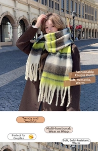 Close-up of thick yellow and grey plaid scarf with long fringe details on the edges