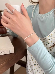 Dettaglio del set di gioielli in argento S925 con fiocco, anello, bracciale e collana