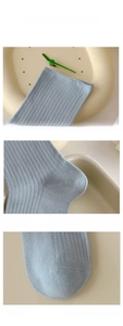 Detail of light blue cotton socks showing ribbed cuffs and reinforced toe stitching