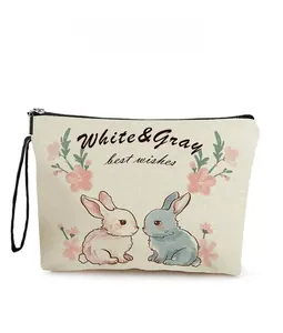 Detailed view of beige canvas makeup bag with colorful rabbit prints and a black zipper