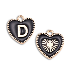 Detail of heart-shaped black enamel pendant with gold D letter and sunburst pattern