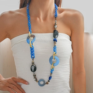 Detail shot of a long acrylic necklace with blue links and resin beads on a model.