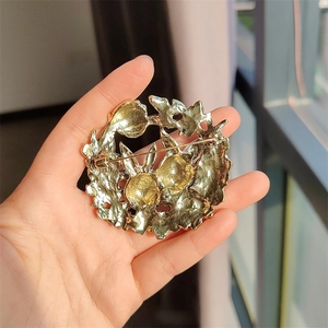 Detail of vintage gold bunny wreath brooch with sparkling rhinestones on the metal surface