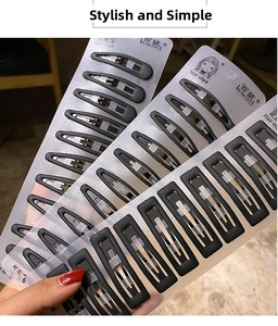 Close-up of matte black metal BB hair clips set on brand card packaging