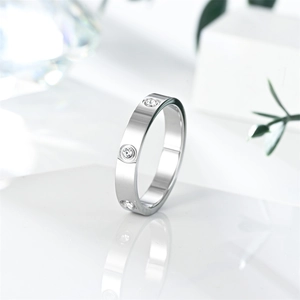 Macro view of silver titanium steel ring featuring screw motifs and inlaid crystal details