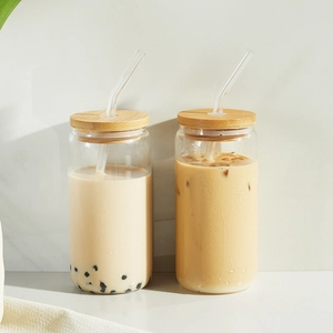 Can-shaped glass cups with bamboo lids and clear straws for iced coffee and boba tea