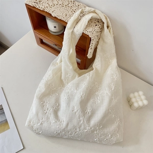 Detail der weißen Einkaufstasche mit 3D-Blumenstickerei und Mesh-Gewebe-Struktur