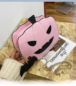 Detailed view of pink pumpkin-shaped bag with black bat charm and golden chain strap