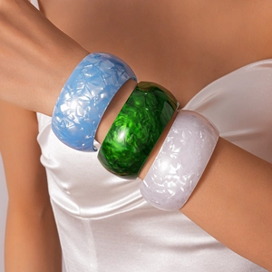 Detailed view of three acrylic bangles in emerald, pearl white, and sky blue finishes