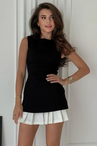 Détail de la coupe ajustée et de l'ourlet blanc plissé sur une robe noire sans manches