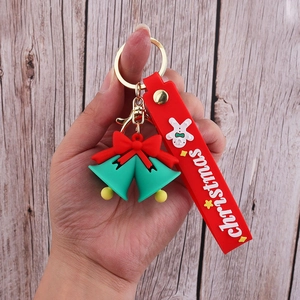Detail of Christmas PVC keychain with red silicone strap and green bell charms