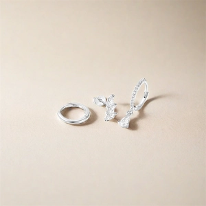 Macro view of S925 sterling silver earring set featuring leaf studs and stone dangles