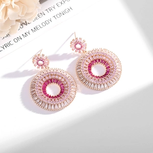 Detailed macro view of large gold-plated hoop earrings with gradient pink and white zircons