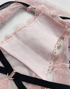 Detailed close-up of pink lace panties featuring a cotton lining and a heart-shaped metal buckle