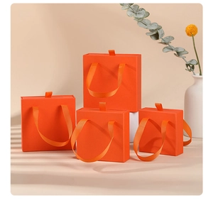 Detail of orange drawer jewelry boxes with ribbon handles and stepped arrangement