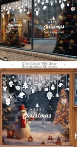 Close-up of white Santa Claus window stickers with snowflakes on glass for holiday decor