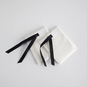 Detailed view of white velvet drawstring jewelry pouches with black ribbon closure