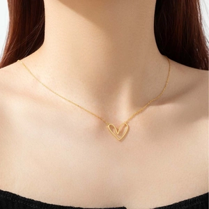 Detailed view of a woman wearing a gold 925 silver minimalist double heart necklace