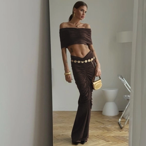 Detail of elegant dark brown two-piece set featuring off-shoulder top and ruched skirt