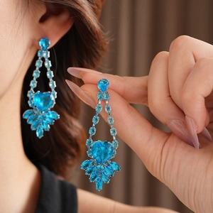Detail view of long blue crystal heart earrings on model for bridal jewelry sets