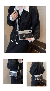 Detail shot of mini camera-shaped crossbody bag with silver hardware and chain strap