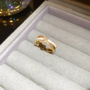 Detail of 18k gold plated criss-cross ring with white enamel and pavé zircon stones
