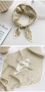 Macro detail of pleated silk scarf with golden diagonal stripes and brand lettering