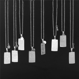 Macro detail of engraved silver zodiac tarot pendants hanging on polished steel chains