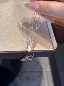 Macro detail of rose gold hollow gourd pendant with pink shell inlay and tiny zircons