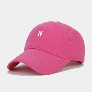 Detailed close-up of the 3D white N embroidery on a hot pink cotton baseball cap