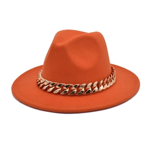 Detailed view of an orange wool fedora hat featuring a chunky gold chain decoration