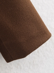 Close-up of premium brown wool fabric showing the thick texture and fiber details