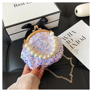 Close-up of white sequin shell bag with large pearl handle and golden chain strap
