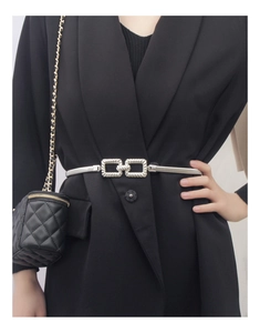 Close-up of silver elastic metal chain belt with rectangular buckle on a black blazer