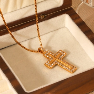 Detailed view of 18K gold plated cross pendant necklace with diamonds in a wooden box