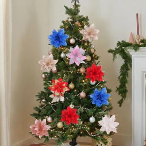 Glittering three-layer artificial poinsettia flowers decorating a festive Christmas tree