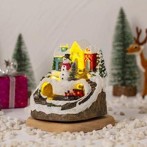 Detail of Christmas glowing house with moving train, snowmen and warm LED lighting